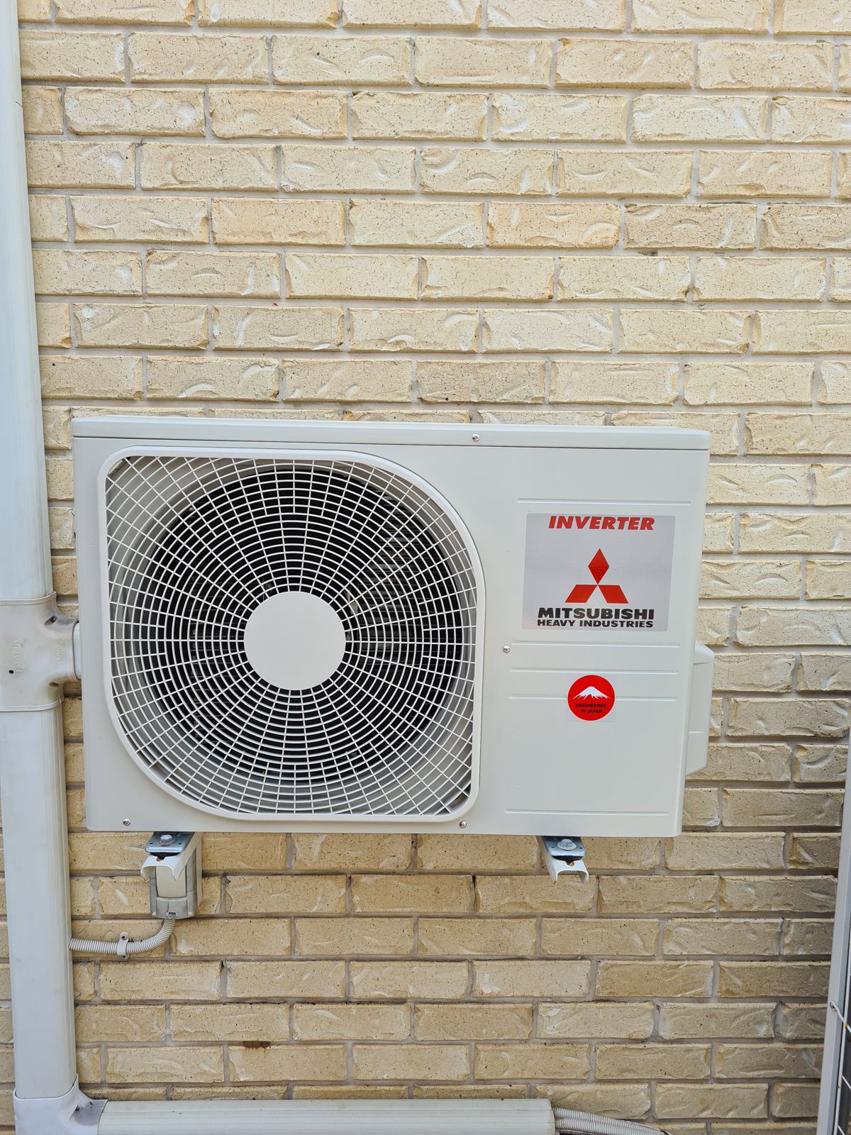Mitsubishi split system outdoor unit on a brick wall